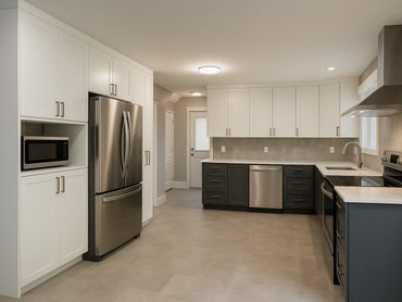 Modern kitchen with stainless steel appliances and white cabinetry.