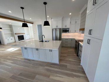 Modern white kitchen with a large island and pendant lights.