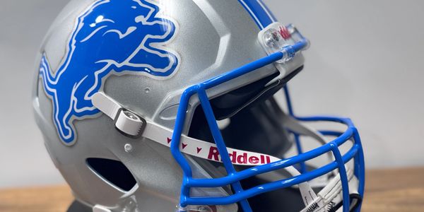 Close-up of a Detroit Lions football helmet with blue lion logo.