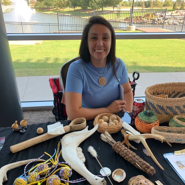 Brittney Cuevas with woven basket and stickball game materials