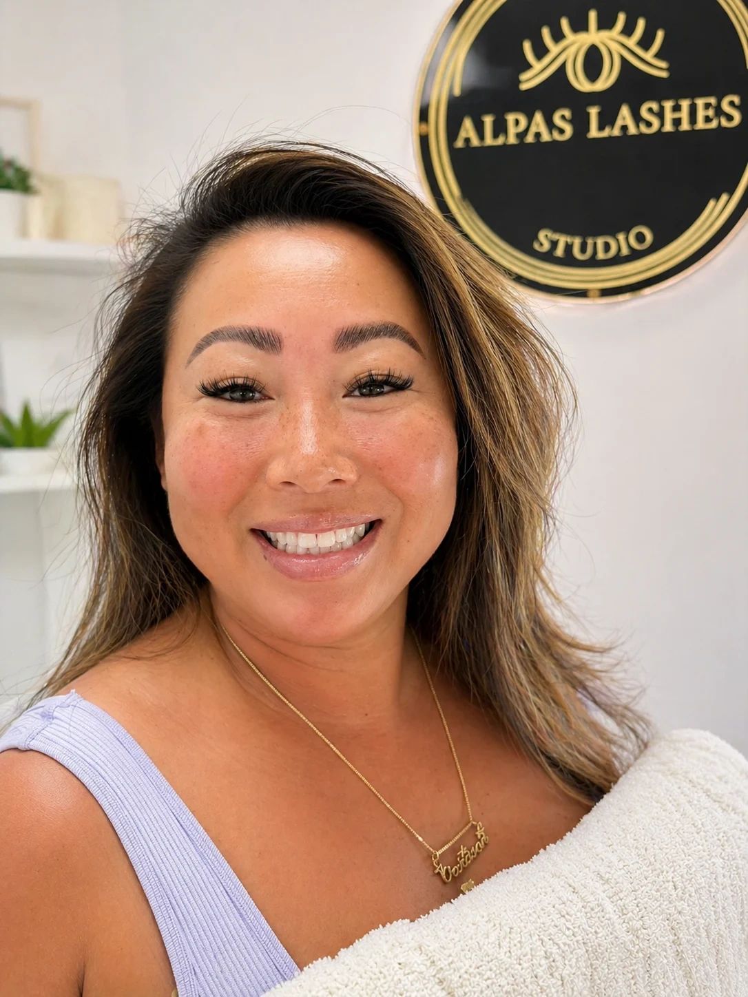 Smiling client portrait at Alpas Lashes Studio showcasing beautifully defined brows.