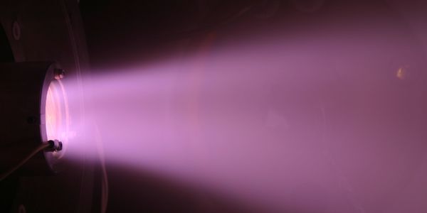 Slightly divergent and non-uniform ion beam from a broad beam ion source