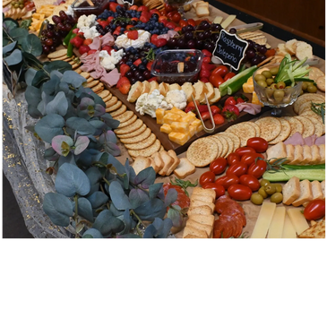 A colorful charcuterie board with various cheeses, meats, fruits, and crackers.