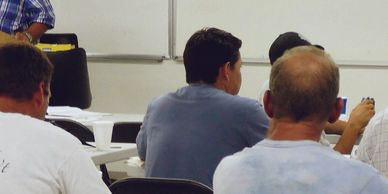 Men seated in a classroom setting.
