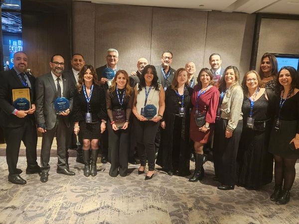 Group photo of professionals holding awards at an event.