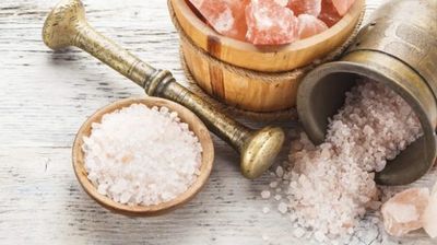 Himalayan pink salt with wooden and metal containers.