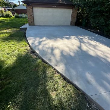 Newly poured concrete driveway leading to a garage.