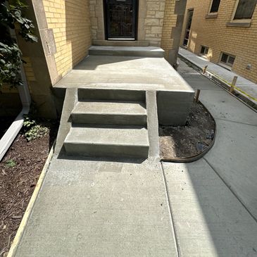 Newly poured concrete steps and porch with fresh sidewalk.