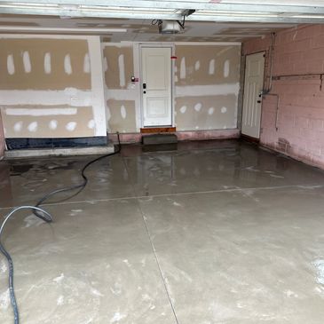 Empty garage with concrete floor and unfinished walls.