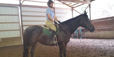 Horse boarded at Brawley Farms and her owner taking an English riding lesson in the indoor arena.