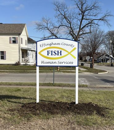 Sign for Effingham County FISH Human Services on a grassy roadside.