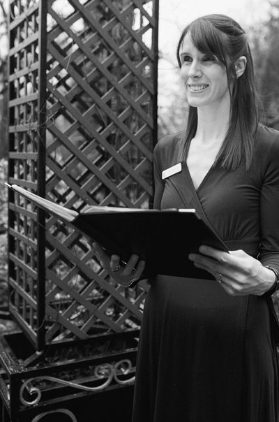 Lady smiling and holding a folder during a ceremony