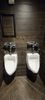 Two urinals with a humorous sign above them.