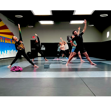 Group practicing yoga in a studio with mats and blocks.