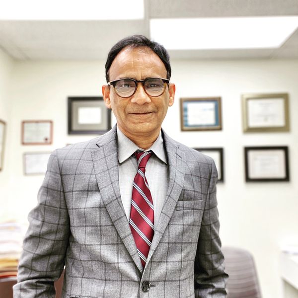 Man in gray checkered suit and red striped tie.