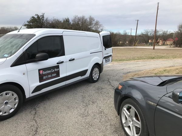 White van and gray car parked near a rural road.