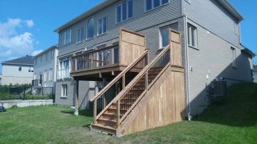 Wooden staircase and deck attached to house.