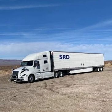 White SRD freight inc. semi-truck with a 53' long reefer trailer.