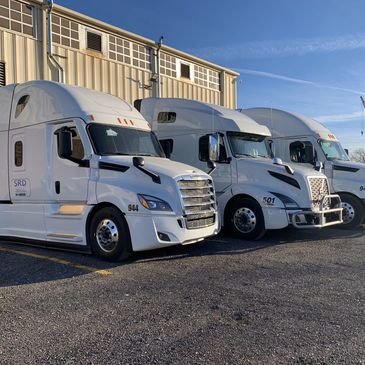 Three white SRD Freight Inc. Semi-Trucks