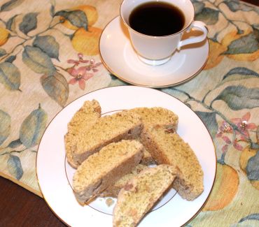 Cup of coffee with biscotti on a plate.