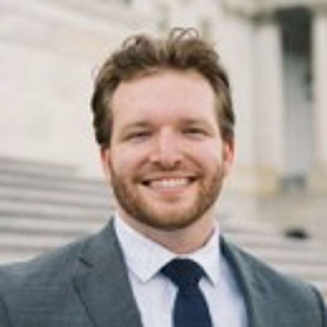 Smiling man in a suit with a tie.
