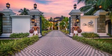 Elegant gated entrance to a luxurious resort at sunset.