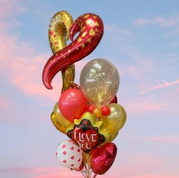 Colorful love-themed balloons against a sunset sky.
