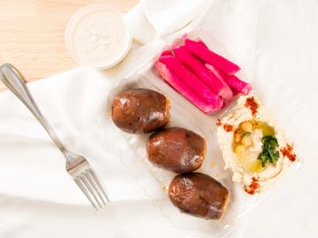 stuffed eggplant with tahini sauce and a side of hummus and turnip pickles