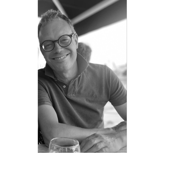 Smiling man with glasses in a casual setting.