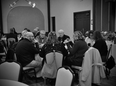 Black and white photo of people sitting around a table at a formal event.