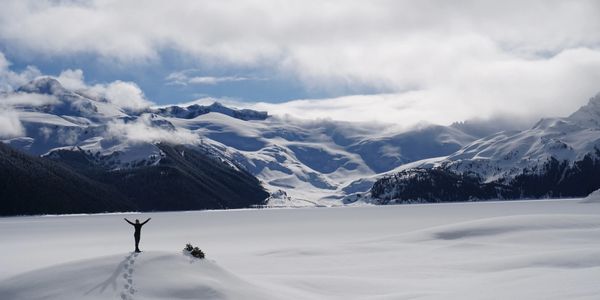 Personal trainer snowshoeing to a beautiful frozen lake in British Columbia