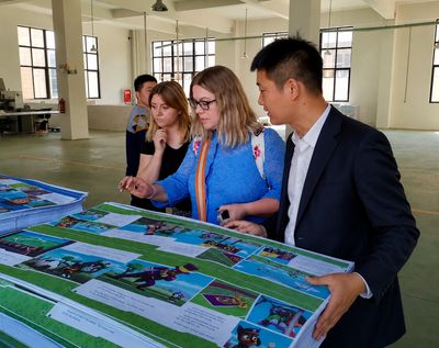 Group examining colorful printed materials indoors.