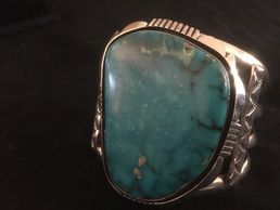 A large blue gem turquoise stone on a heavy cuff