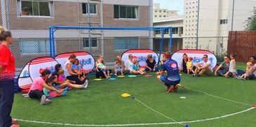 Playball coach and children on sport field