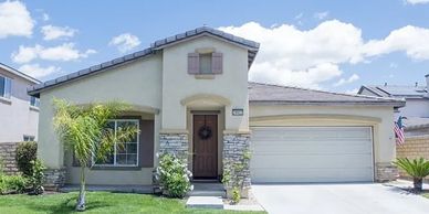 A modern single-story house with a two-car garage and a small front yard.