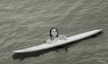 Person submerged in water with a board on top.