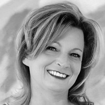 Smiling woman with light hair in black and white photo.