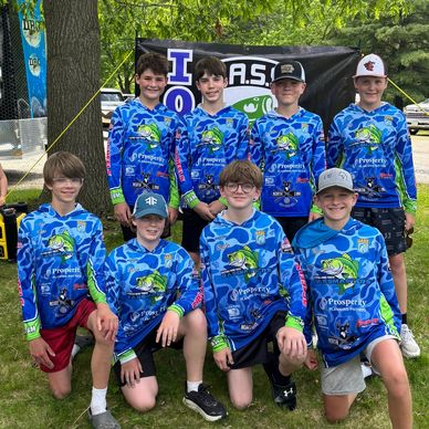 Youth fishing team in matching blue jerseys posing outdoors.