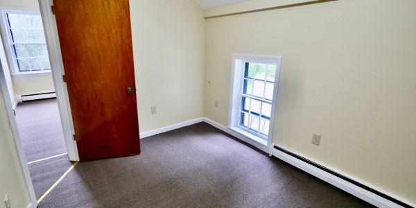 Empty room with beige walls and carpet flooring.