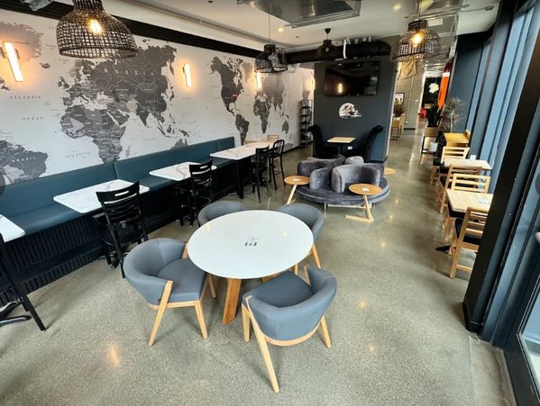 Modern cafe interior with world map wall and mixed seating.