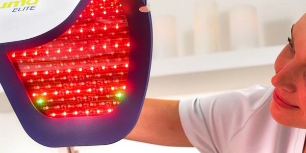 Person holding a red light therapy device.