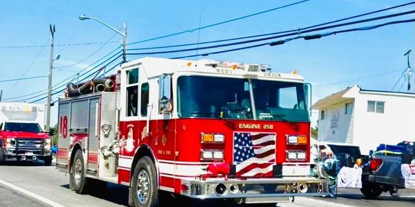 A red fire truck with an American flag design on the front grille on a street.