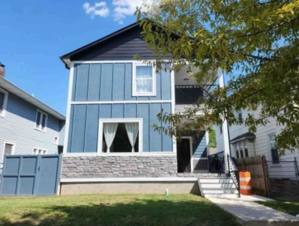 Blue and white two-story house with a neat lawn.