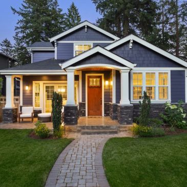 Blue house with warm lights and stone pathway.