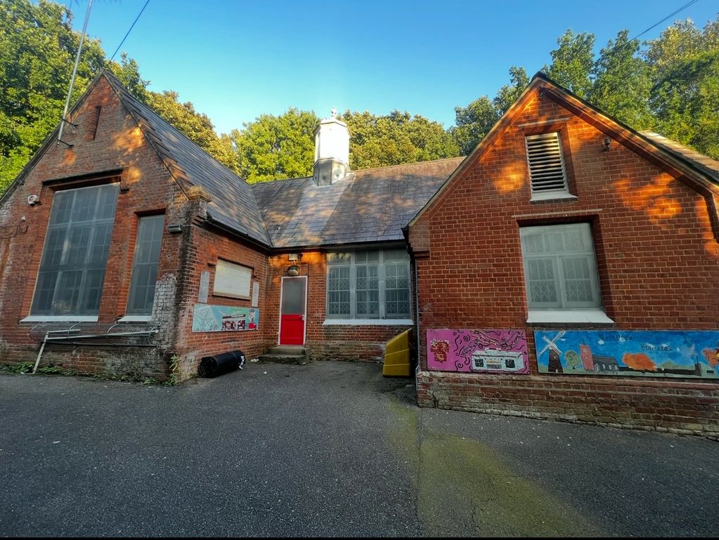 Old brick building with colorful murals on the walls.
