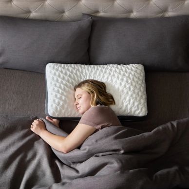 Woman peacefully sleeping with a white pillow.