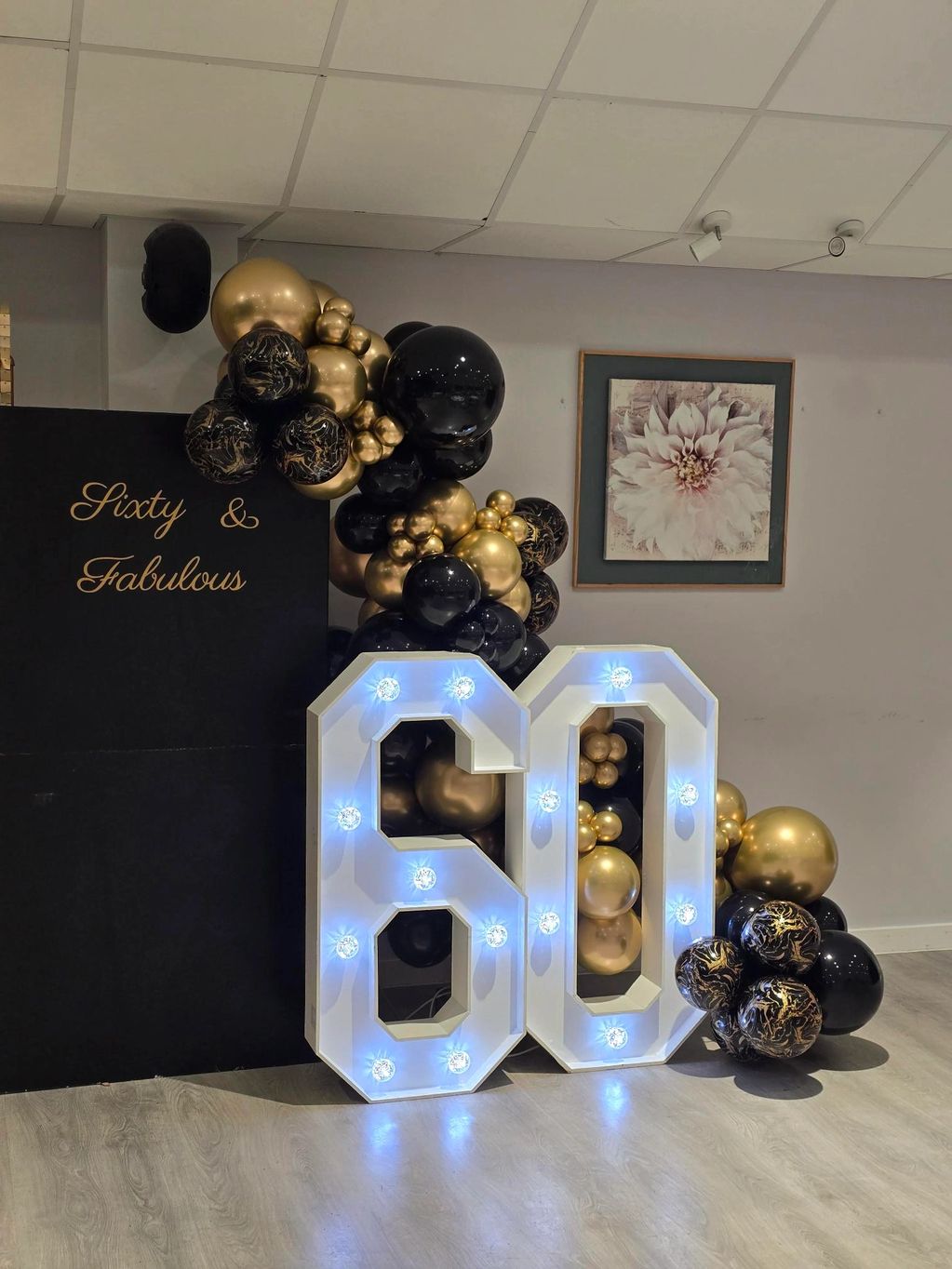 60th birthday celebration decor with black and gold balloons.