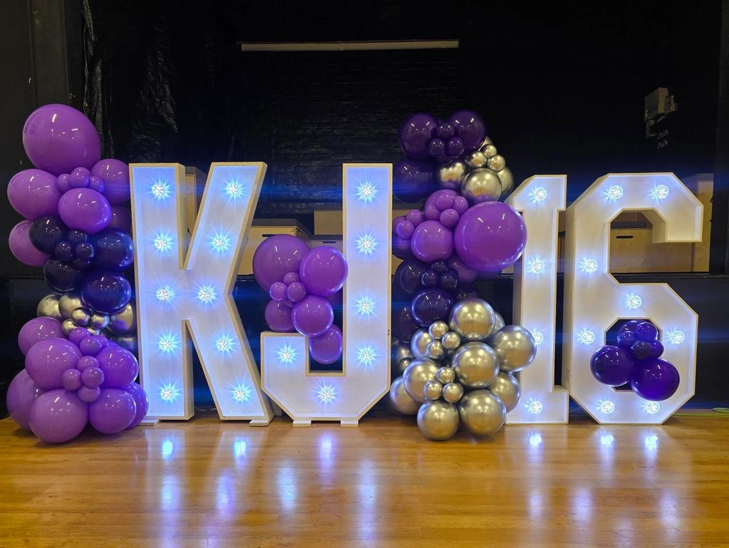 Lighted letters KJ16 with purple and silver balloon decorations.