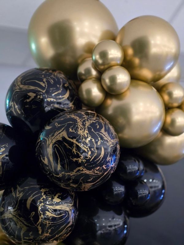 Cluster of black and gold marbled balloons.