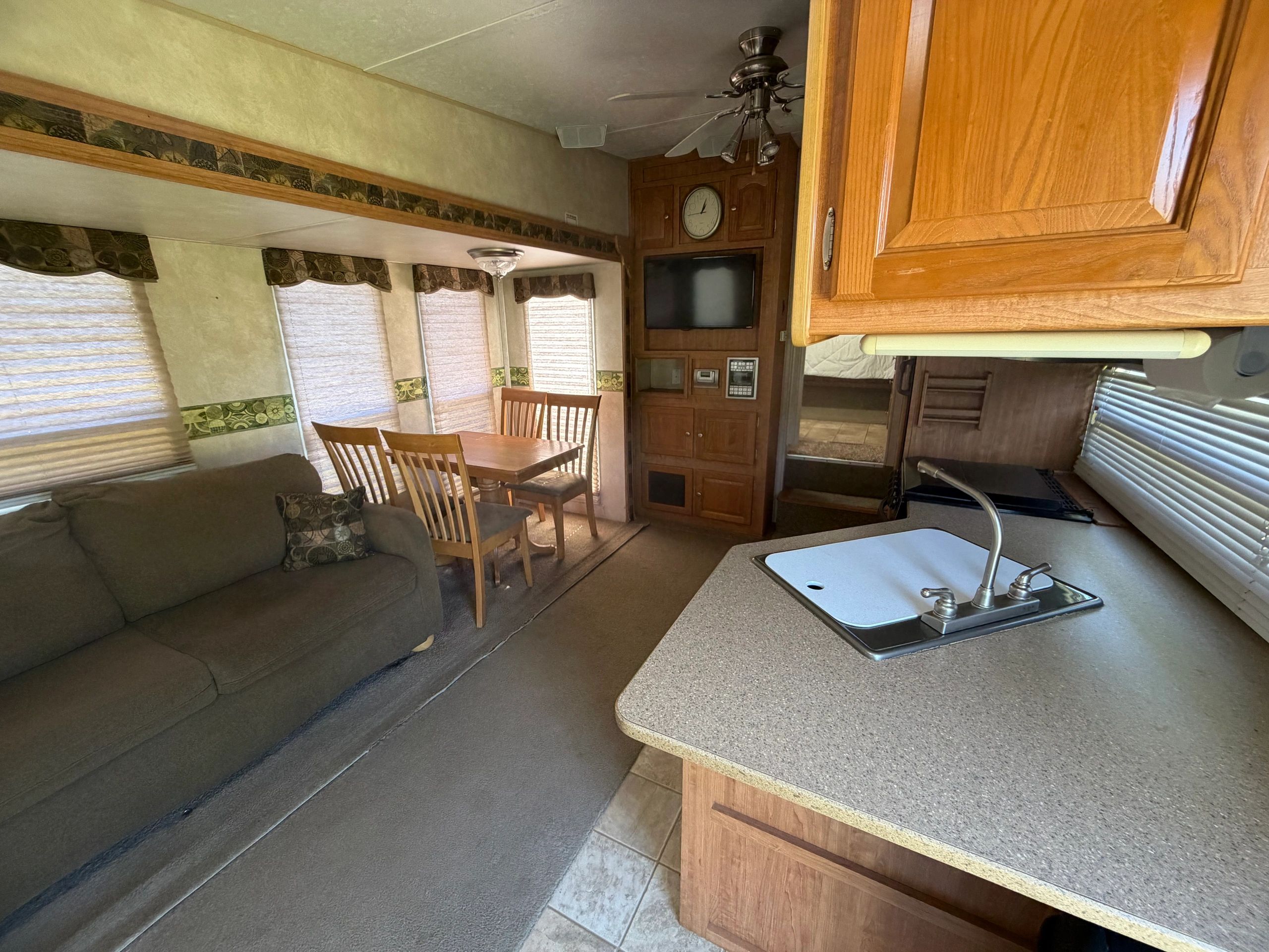 Interior of a cozy RV with kitchen, dining, and living space.